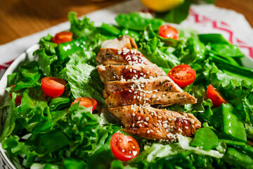 healthy chicken salad with lettuce, green peas, cherry tomatoes, olive oil dressing