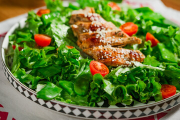 healthy chicken salad with lettuce, green peas, cherry tomatoes, olive oil dressing