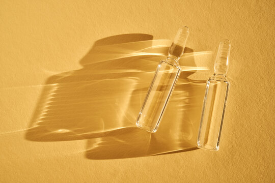 Glass ampoules creating shadows under warm sunlight