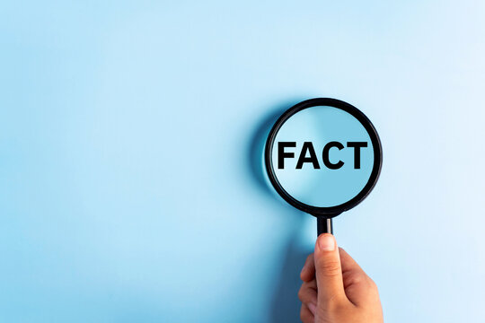 Fact - Word through magnifying glass on blue background.
