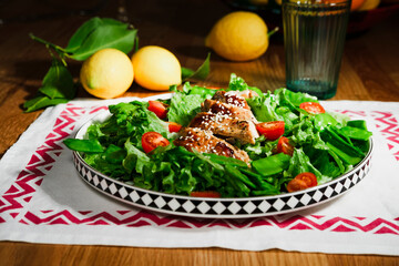 mediterranean styled salad with green lettuce leaves, peas, grilled chicken meat, cherry tomatoes, dressed with olive oil, served for one