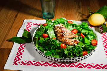 grilled chicken salad with green lettuce, grilled meat, green peas, tomatoes, lemons, fresh natural healthy mediterranean styled meal