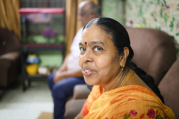 Elderly woman smiling while sitting indoors with family