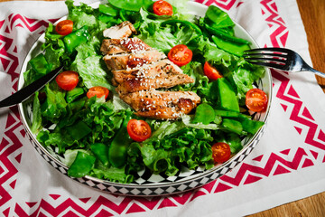 grilled chicken salad with green lettuce, grilled meat, green peas, tomatoes, lemons, fresh natural healthy mediterranean styled meal