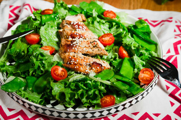 grilled chicken salad with green lettuce, grilled meat, green peas, tomatoes, lemons, fresh natural healthy mediterranean styled meal