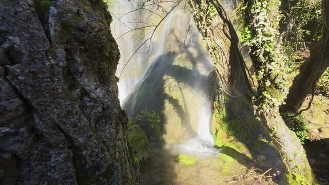 Detailed shot of the water cascading over the unique, mossy rock formations of the Fuentetoba waterfall, highlighting the vibrant green colors and textures of this natural wonder in Castilla y Le&oacute;n.