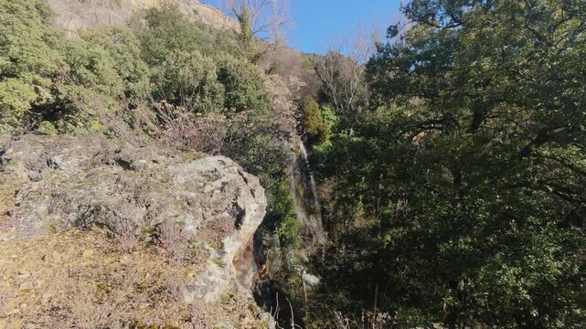 Breathtaking view of the Fuentetoba waterfall cascading down a large rock formation covered in green moss, a stunning example of the natural beauty found in the landscapes of Soria, Castilla y Le&oacute;n.