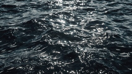 Dark ocean water with shimmering light reflections on the surface.