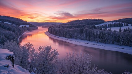 Snow-covered river at sunset with colorful sky and winter landscape, surrounded by hills and forest.