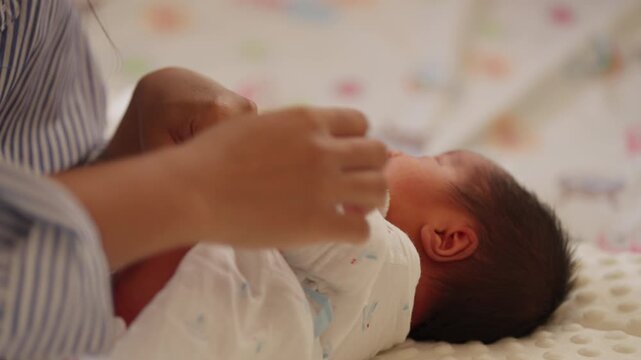 Real moment of newborn baby crying after bath, wrapped in a cozy white blanket and held by parent.