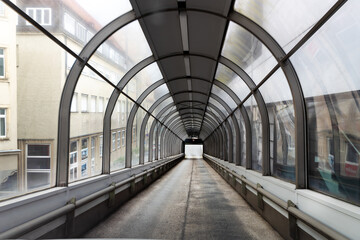 Covered exit with transparent arched roof from a multi-storey car park facing surrounding building facades