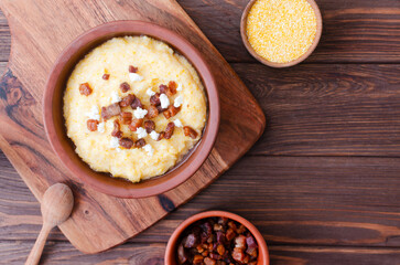 Traditional Banosh with cheese and bacon in rustic ceramic bowl