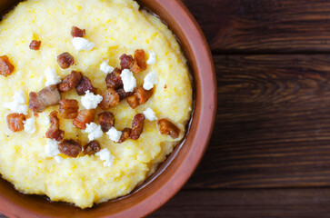 Traditional Banosh with cheese and bacon in rustic ceramic bowl