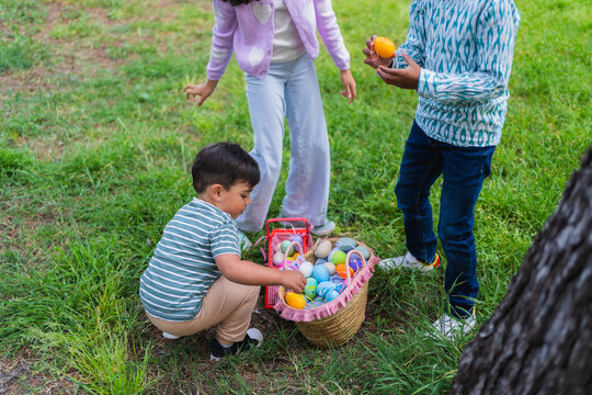 Children enjoying an outdoor easter egg hunt in a grassy area