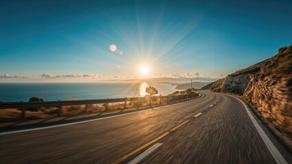 Fototapeta premium A scenic highway view with the sun rising over the ocean and a curving road along the cliffs. Nature and travel scene. The concept of road trip and scenic drives.