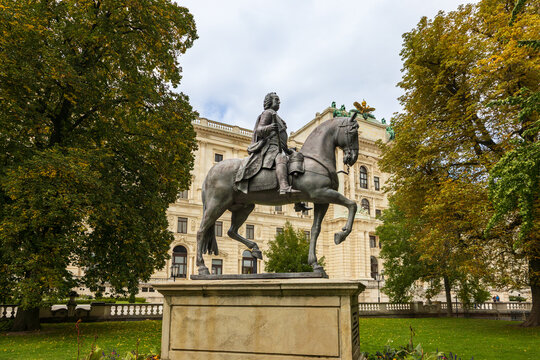 The 1781 Franz Stephan&rsquo;s equestrian cast lead statue in the Burggarten, with fall foliage and Neue Burg (New Palace) in the background, Vienna, Austria