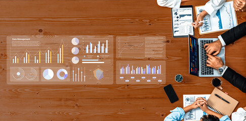 A diverse business team collaborates over data management using modern technology, featuring charts and graphs, enhancing decision-making and strategic analysis. Gantry