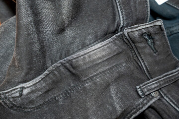 Close-up of black denim jeans showcasing stitching details, fabric texture, and pockets. Ideal for fashion advertising, clothing store promotions, or online retail contexts.