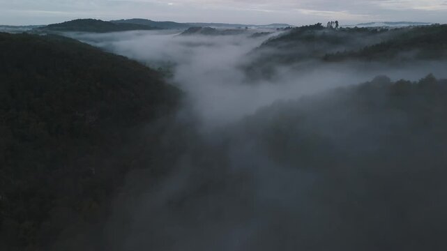 Aerial of hills and forest countryside in the fog