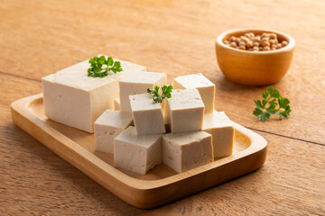 Sliced block tofu,Hard white Tofu soy bean curd on a wooden plate.