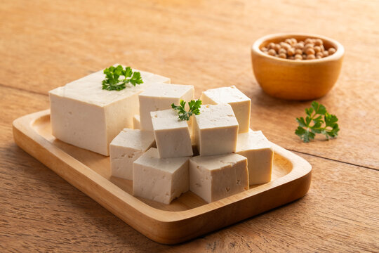 Sliced block tofu,Hard white Tofu soy bean curd on a wooden plate.