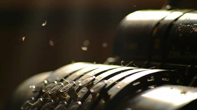 Close-up of vintage calculator with falling debris, dark background, finance, retro, antique, old, calculator, financial themes.