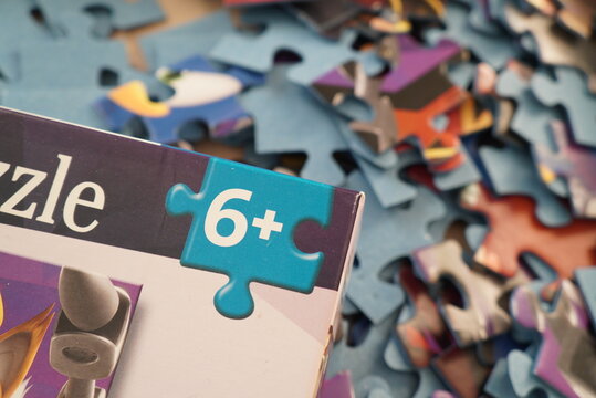 Close-up of a puzzle box with a '6+' age rating and scattered pieces