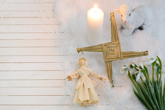 St brigid's cross, doll, lamb, candle, and snowdrops celebrating imbolc
