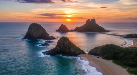 Sunset over coastal rocks and sandy beach with waves and colorful sky