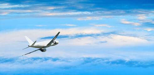 Airplane flying over the clouds high in the blue cloudy sky, airplane in the flight background