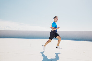 Runner moving on a rooftop in bright sunlight