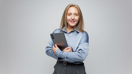 Woman holding a notebook and smiling in a studio setting
