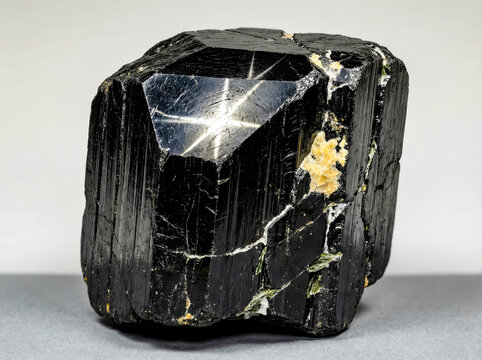A collectible geological specimen of polished black star diopside with a four rayed asterism effect.