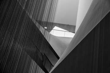 Naklejka premium Abstract Monochrome Architectural Interior Featuring Textured Metal Curtains and Geometric Concrete Shapes