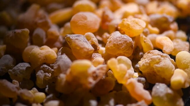 Frankincense olibanum resin, Boswellia sacra background. Frankincense or olibanum aromatic resin used in incense and perfumes, rotating backdrop, design, macro shot, top view. 