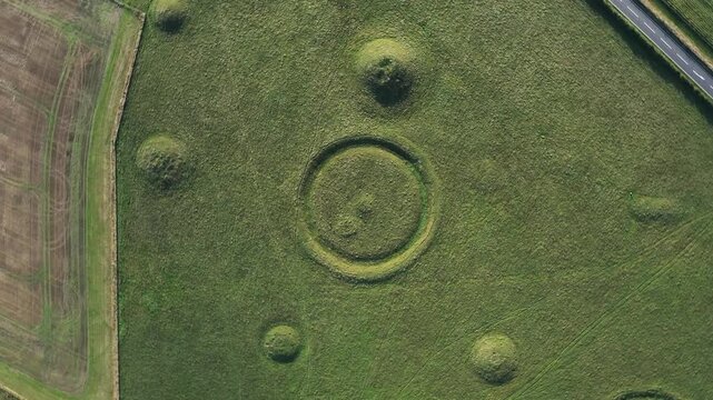 Oakley Down Barrow Cemetery, Dorset. Birdseye view of part of main group. Bronze Age mounds and disc barrows. Inhumation and cremation burials. Fly up rotate clockwise