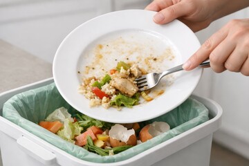 Household Food Waste Disposal And Kitchen Cleanup Process.
Hands scraping leftover food into kitchen trash bins, illustrating household food waste disposal, sustainability habits.