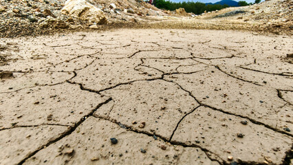 Dry cracked earth scene. The arid soil illustrates drought conditions, and the landscape is full of cracks