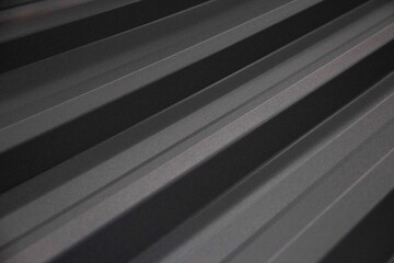 Obraz premium Black gray profiled metal sheet with diagonal ridges and soft shadow