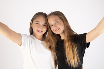 Two happy girls taking a selfie and smiling.