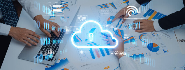 Hands engaged in a data analysis session using a laptop and charts, representing collaboration in a cloud computing environment in a modern office. Trope