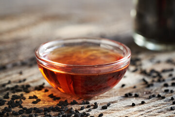 Black cumin or Nigella sativa seed oil in a bowl. Healthy anti-inflammatory and antioxidant...