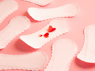 Seamless pattern of white feminine sanitary pads with red paper hearts on pink background menstruation hygiene concept