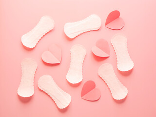 Seamless pattern of white sanitary pads and red paper hearts on pink background menstruation and feminine hygiene concept