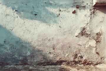 Old painted wall with peeling faded paint and natural wear creating authentic textured background for design use