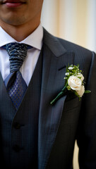 Groom wearing boutonniere photo, elegant cropped shot, minimalist wedding photography, no face visible, refined stylish suit detail, shallow depth of field, stock image