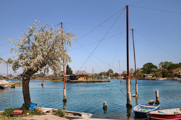 Ravenna, Emilia Romagna, Italy: landscape of the canals with fishing huts and boats in the lagoon on the Adriatic sea coast
