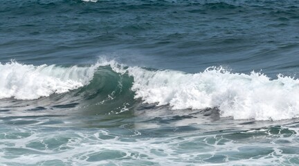 Naklejka premium Ocean wave crashing with sea foam and spray in sunny weather conditions