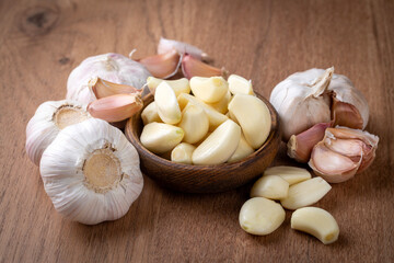 Garlic cloves in a glass bowl with peeled garlic