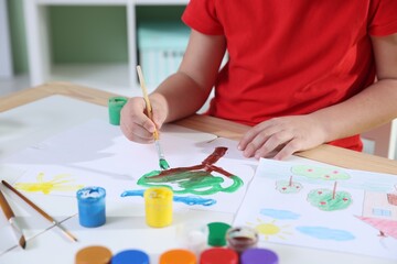 Naklejka premium Little boy painting with brush at table indoors, closeup
